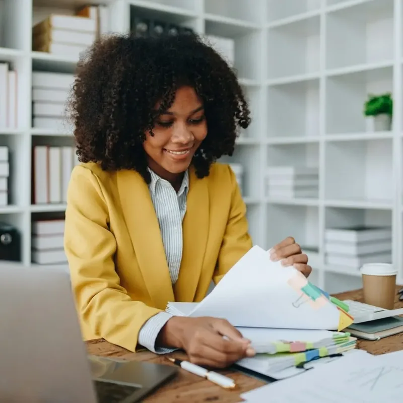 Woman smiling while reviewing VAT paperwork in a Nairobi office – Zidika Consulting