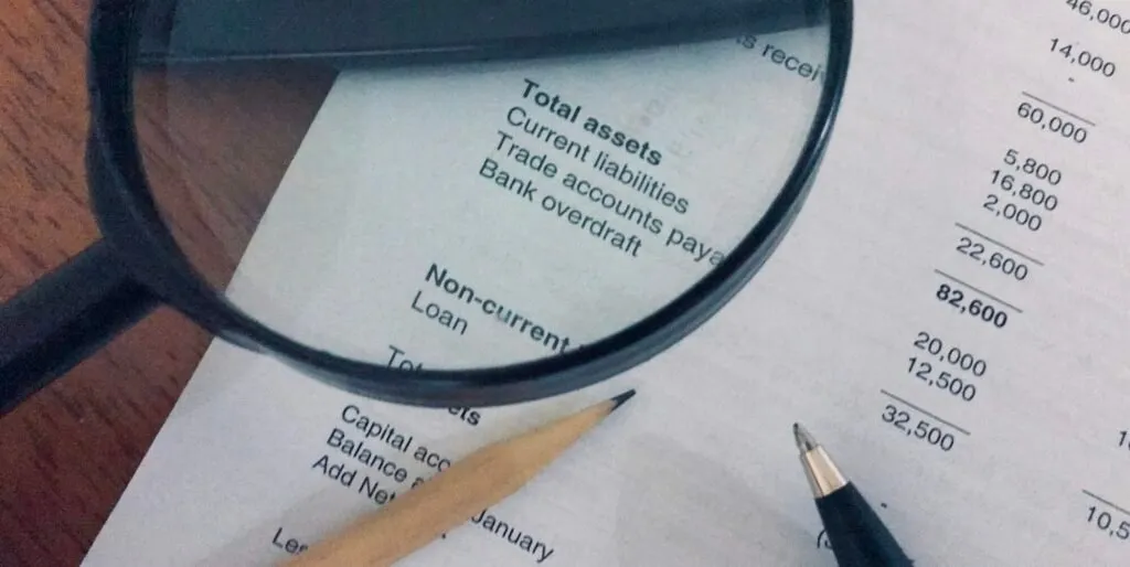 Financial statement on a desk with a pen and magnifying glass – Zidika Consulting Kenya
