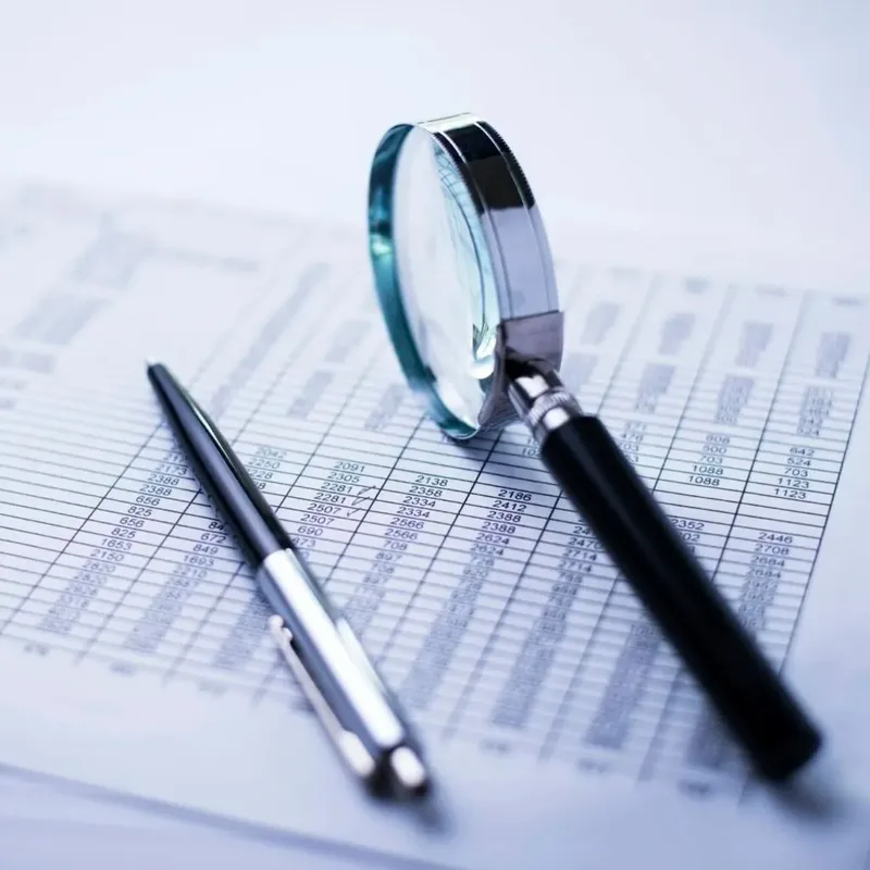 Tax report with a magnifying glass used for freelancer filing in Kenya – Zidika Consulting