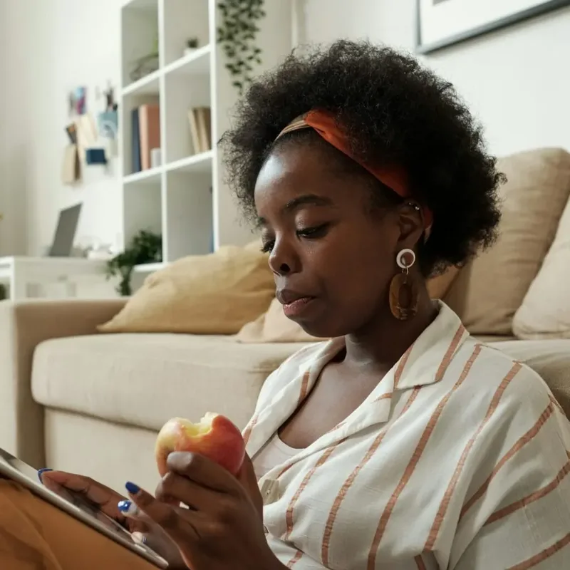 Kenyan freelancer seated at home reviewing tax details on her iPad – Zidika Consulting