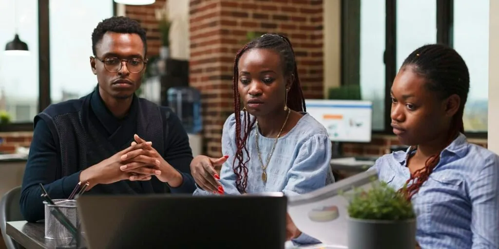 Three professionals in a Nairobi office reviewing outsourced accounting data – Zidika Consulting, Kenya