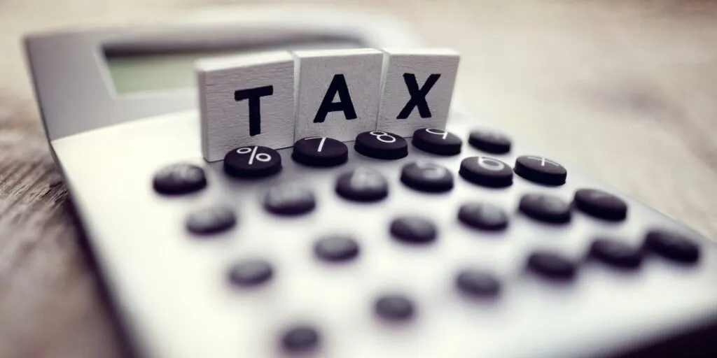 Wooden TAX blocks on top of a calculator for deduction planning – Zidika Consulting, Kenya
