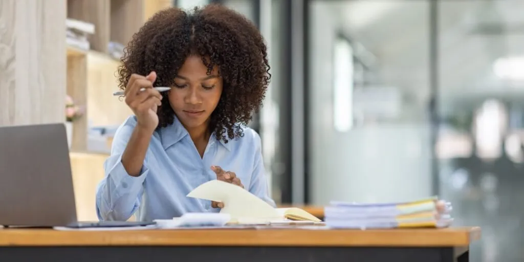 Woman reviewing notebook on withholding tax compliance at a Nairobi office – Zidika Consulting, Kenya